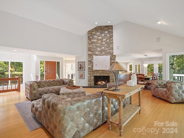 living room featuring light wood-type flooring, high vaulted ceiling, and a wealth of natural light