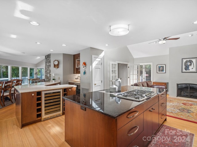 kitchen featuring lofted ceiling, plenty of natural light, light hardwood / wood-style floors, and a spacious island