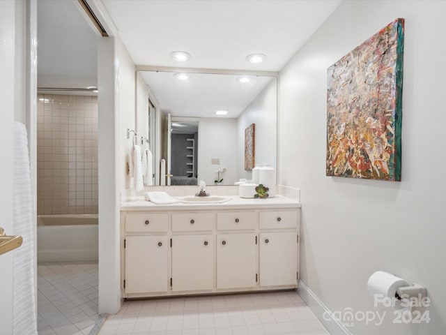 bathroom with tiled shower / bath, vanity, and tile patterned flooring