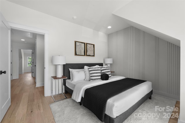 bedroom featuring light wood-type flooring and vaulted ceiling