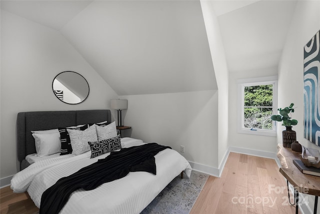 bedroom featuring light hardwood / wood-style flooring and vaulted ceiling