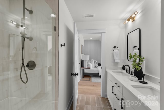 bathroom with walk in shower, vanity, and hardwood / wood-style flooring