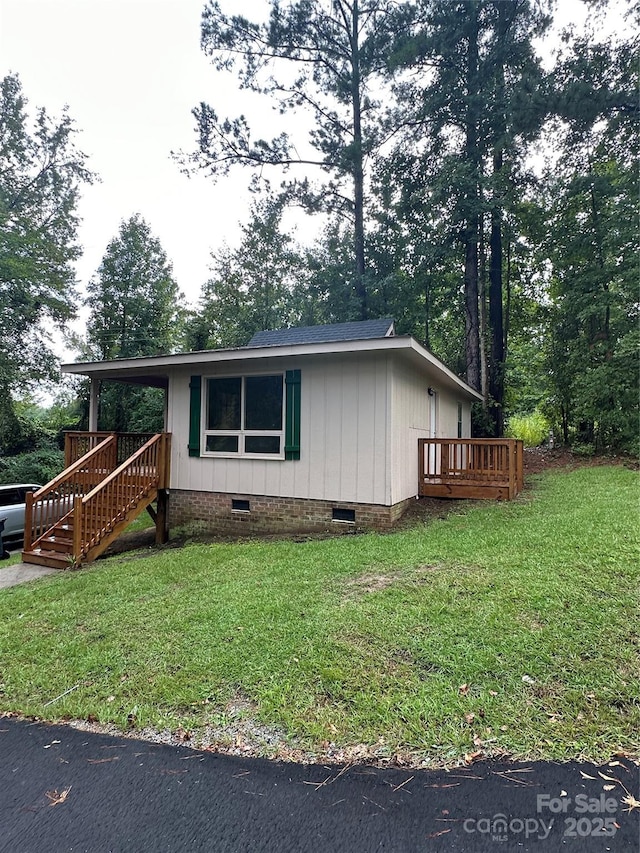 view of front of house featuring a front lawn and a deck