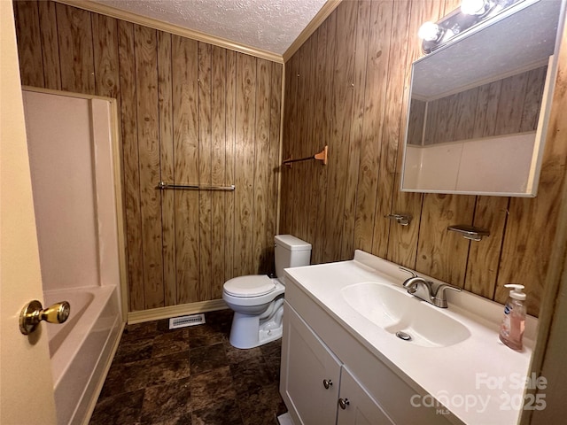 full bathroom featuring vanity, toilet, a textured ceiling, and wood walls