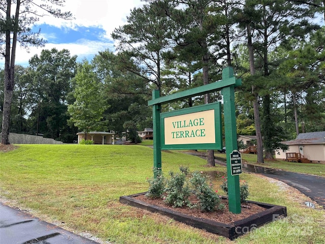 community / neighborhood sign featuring a yard