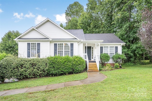 single story home featuring covered porch and a front yard