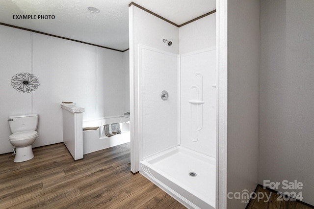 bathroom with a shower, hardwood / wood-style floors, toilet, and a textured ceiling