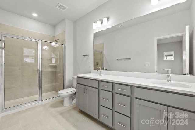 bathroom featuring tile patterned floors, an enclosed shower, vanity, and toilet