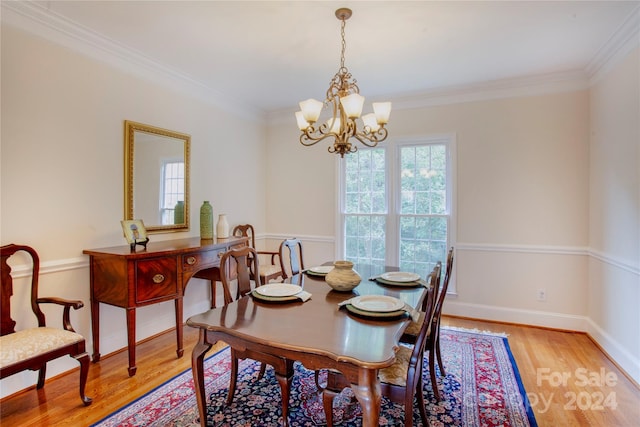 dining room with an inviting chandelier, crown molding, and light hardwood / wood-style flooring