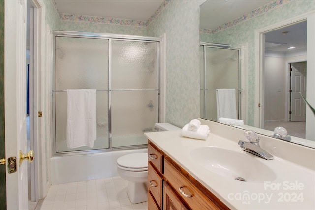 full bathroom with toilet, combined bath / shower with glass door, vanity, and tile patterned floors