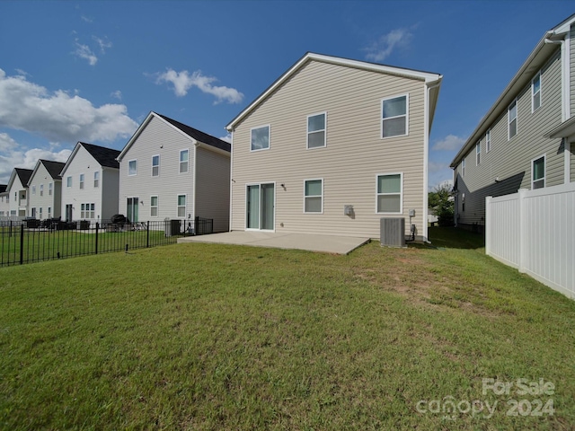 rear view of house with a lawn, a patio, and central AC