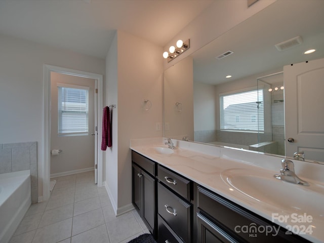 bathroom featuring vanity, tile patterned flooring, and a washtub