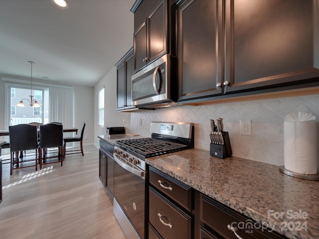 kitchen with pendant lighting, light hardwood / wood-style floors, appliances with stainless steel finishes, and plenty of natural light