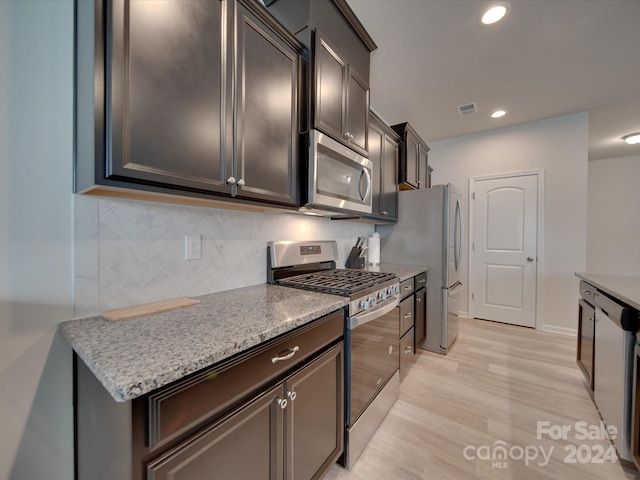 kitchen with light hardwood / wood-style flooring, stainless steel appliances, decorative backsplash, and dark brown cabinetry