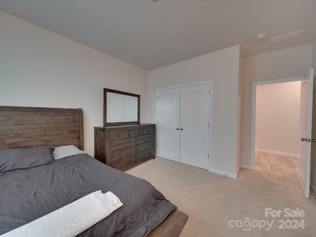 bedroom with light colored carpet and a closet