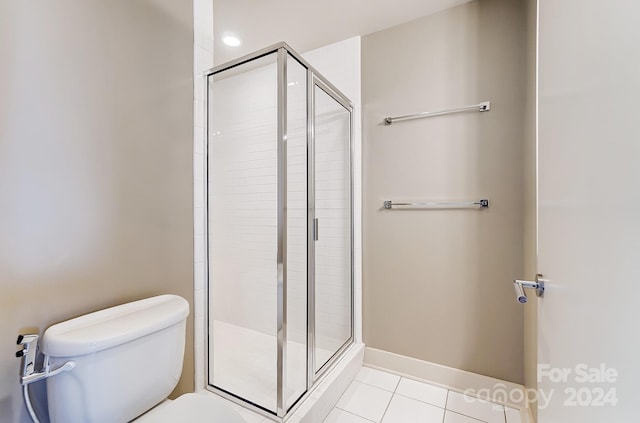 bathroom featuring walk in shower, toilet, and tile patterned floors