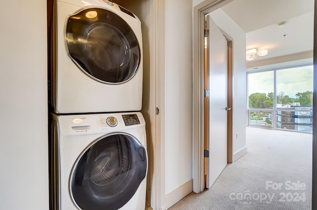 laundry room featuring light carpet and stacked washer / drying machine