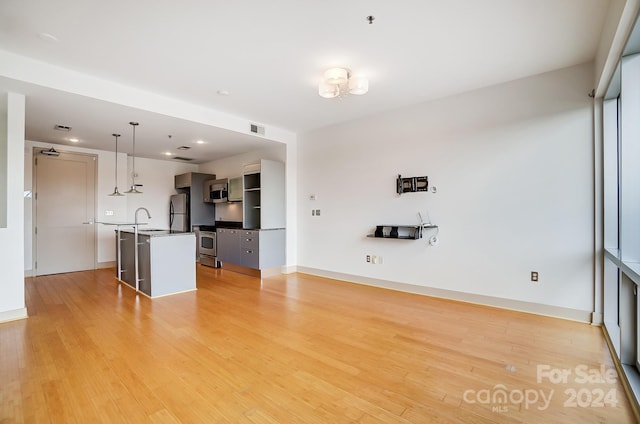 unfurnished living room with light hardwood / wood-style flooring and sink