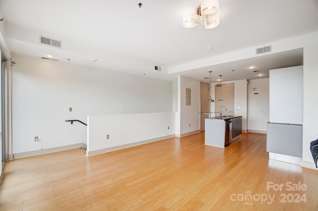 unfurnished living room with light hardwood / wood-style flooring and sink