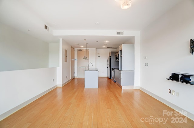 unfurnished living room featuring light hardwood / wood-style floors and sink