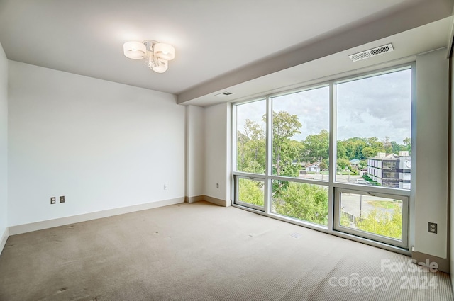 spare room with an inviting chandelier and carpet flooring