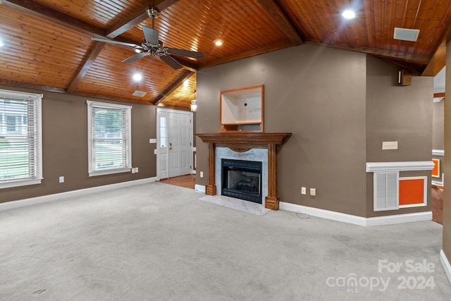 unfurnished living room with a premium fireplace, ceiling fan, wooden ceiling, and a healthy amount of sunlight