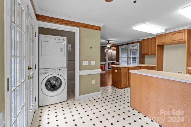 washroom with ornamental molding, ceiling fan, and stacked washer and clothes dryer