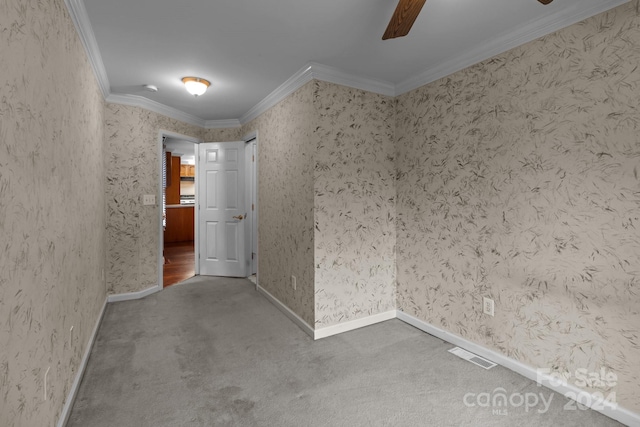 spare room featuring ornamental molding, ceiling fan, and carpet flooring