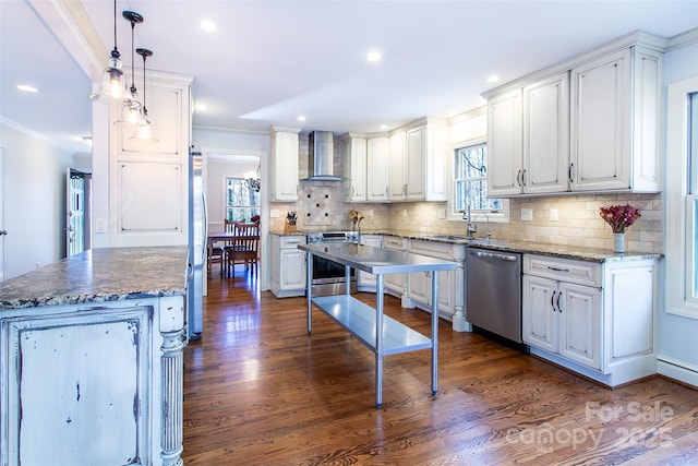 kitchen with a kitchen island, decorative light fixtures, white cabinetry, stainless steel appliances, and wall chimney exhaust hood