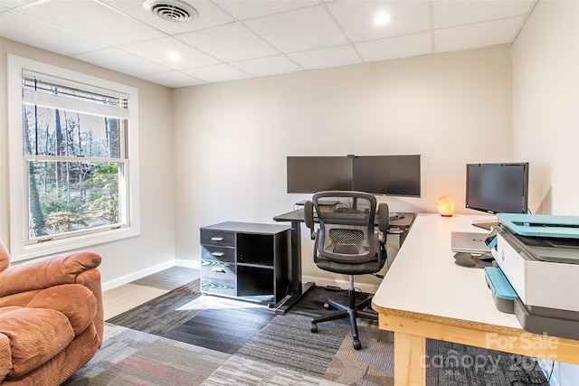 carpeted office space featuring a paneled ceiling