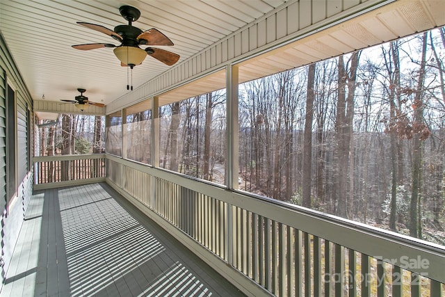 unfurnished sunroom with ceiling fan