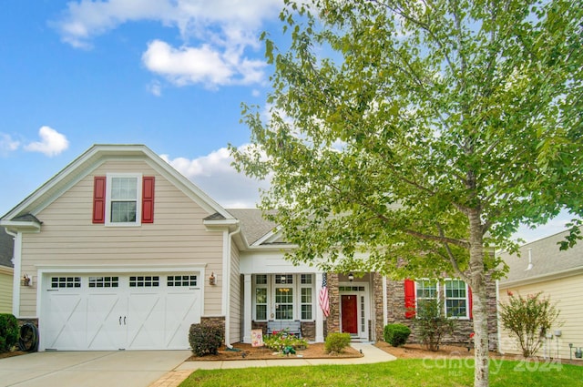 view of front of home with an attached garage, stone siding, a front lawn, and concrete driveway