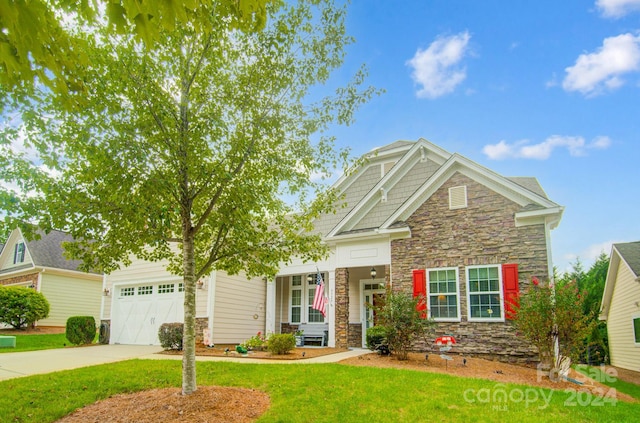 craftsman inspired home featuring stone siding, an attached garage, a front yard, and concrete driveway