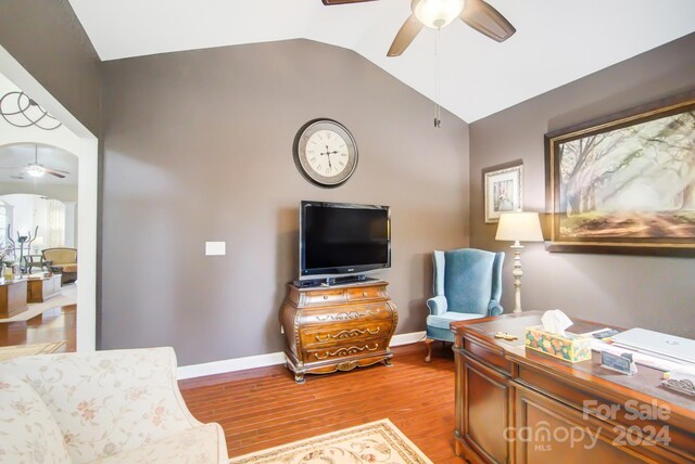 interior space featuring baseboards, a ceiling fan, wood finished floors, and vaulted ceiling