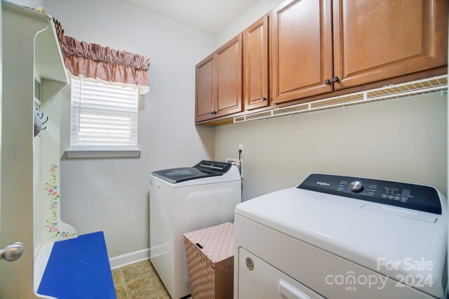 laundry area with cabinet space, baseboards, and washer and clothes dryer