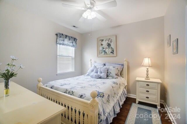 bedroom featuring a ceiling fan, baseboards, dark wood-style flooring, and visible vents