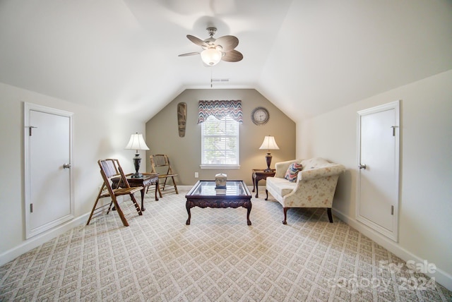 sitting room featuring baseboards, vaulted ceiling, light colored carpet, and ceiling fan