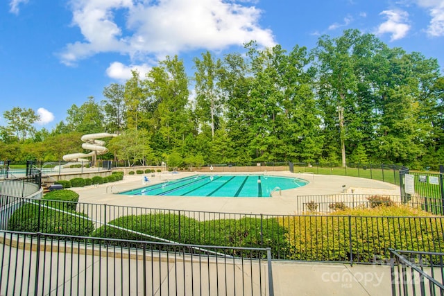 view of swimming pool featuring a water slide and a patio area