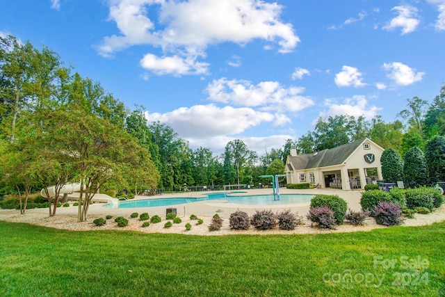 view of pool featuring a lawn and a patio area