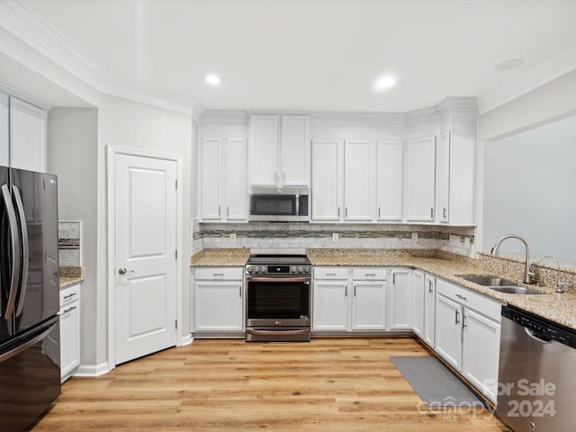 kitchen featuring sink, white cabinets, light hardwood / wood-style flooring, appliances with stainless steel finishes, and ornamental molding