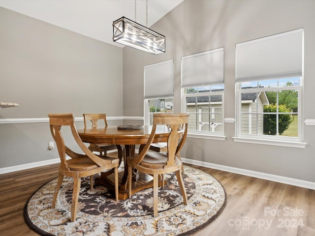 dining space featuring wood-type flooring and lofted ceiling