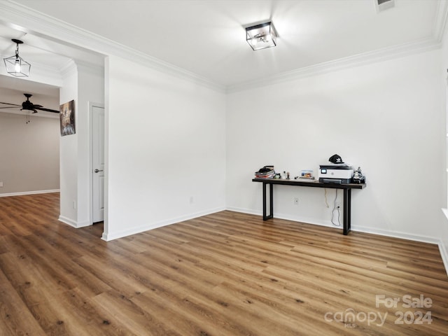 empty room with ceiling fan, ornamental molding, and wood-type flooring