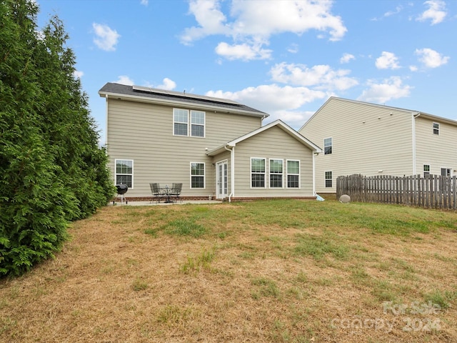 back of property featuring a lawn and a patio