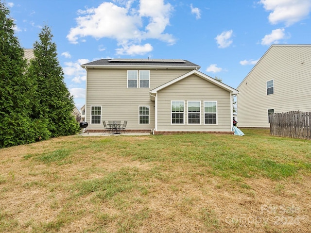 back of property with a yard and a patio