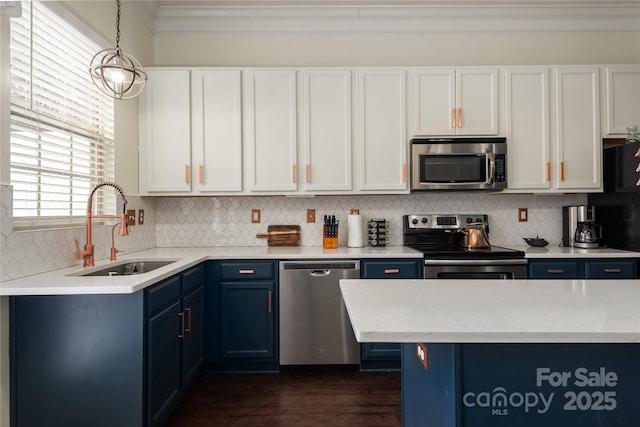 kitchen with sink, white cabinetry, hanging light fixtures, stainless steel appliances, and blue cabinets