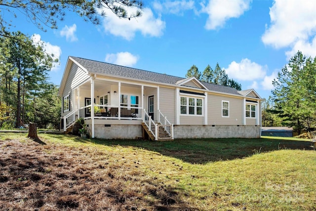 rear view of house featuring a porch and a lawn