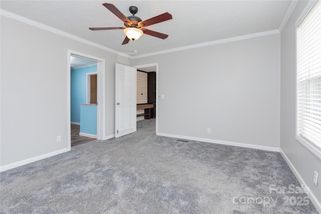 carpeted empty room with ceiling fan and ornamental molding