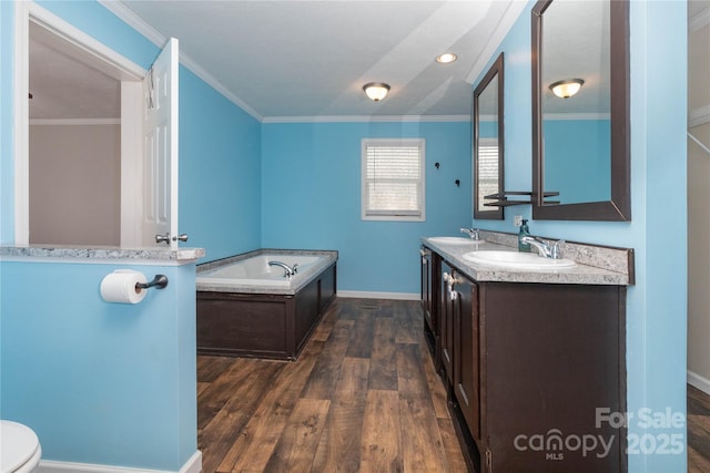 bathroom with hardwood / wood-style floors, a bathtub, vanity, ornamental molding, and toilet