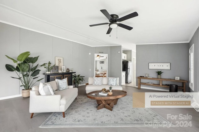 living room featuring hardwood / wood-style flooring, ceiling fan, and crown molding