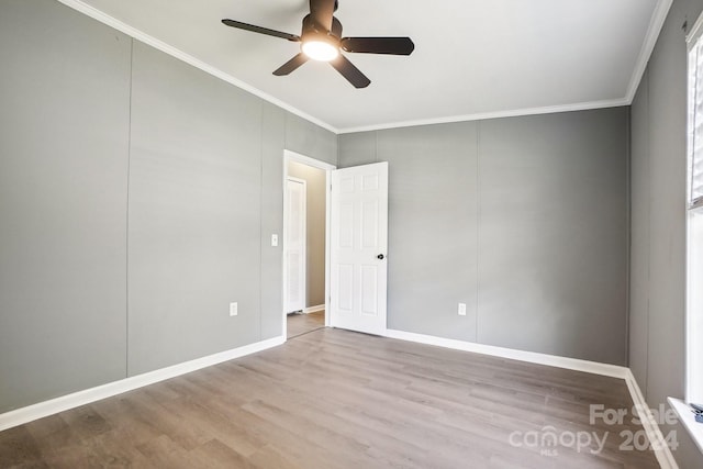 spare room with ornamental molding, light wood-type flooring, and ceiling fan